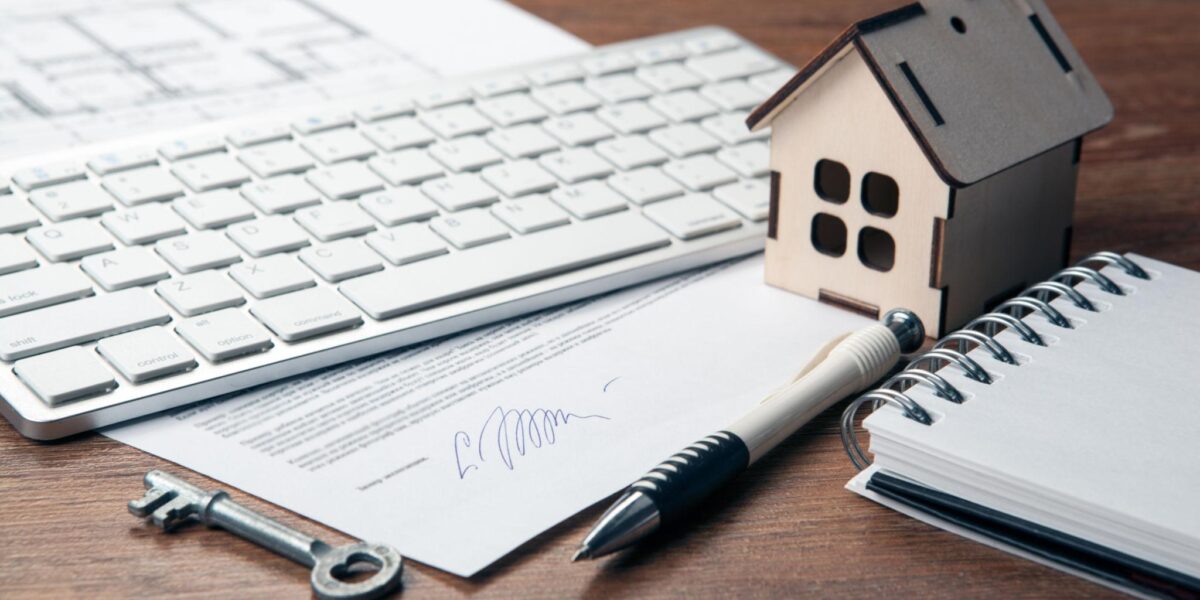Home loan documents with house model and keys representing property financing and mortgage approval